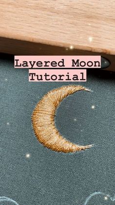 an embroidered moon is shown with the words layered moon written in gold on it