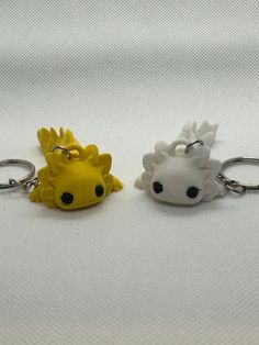 two keychains with animals on them sitting next to each other