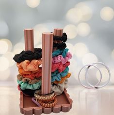 a stack of hair ties sitting on top of a table next to a pair of rings