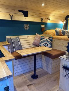 a room filled with lots of furniture next to a wooden table and bed on top of a hard wood floor