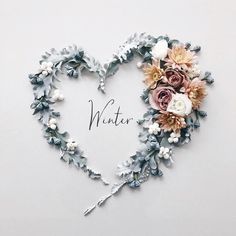 a heart made out of flowers and leaves with the word winter written in it's center