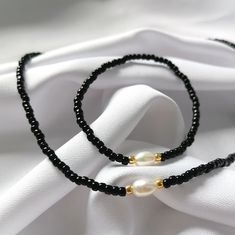 Black Round Beads Jewelry For Beach, Beach Jewelry With Gold And Black Beads, Black Minimalist Jewelry With Pearl Charm, Minimalist Black Jewelry With Pearl Charm, Gold Jewelry With Black Beads For The Beach, Minimalist Black Jewelry For The Beach, Minimalist Black Jewelry For Beach, Black Beaded Necklaces With Pearl Charm Gift, Gift Black Beaded Necklaces With Pearl Charm