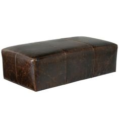 a large brown leather ottoman sitting on top of a white floor