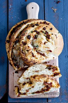 a loaf of bread sitting on top of a wooden cutting board