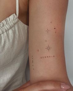 a woman's arm with the word scorpi written in small stars on it