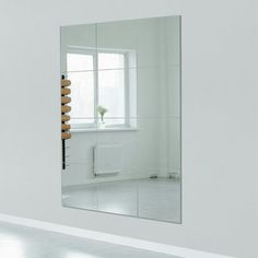 a white room with a large mirror on the wall and a plant in the corner