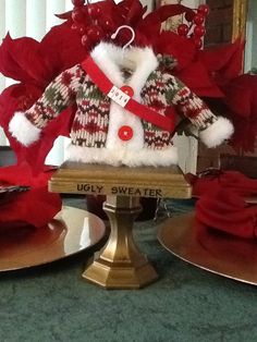 a teddy bear wearing a red and white jacket with poinsettis around it