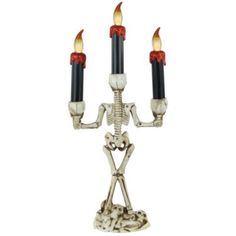 a skeleton candelabra with three candles in the shape of a human figure