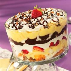 a trifle with strawberries and whipped cream on top is sitting on a table