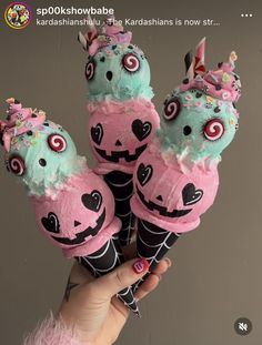 three ice cream cones decorated with pink and blue frosting