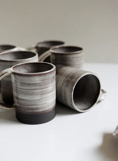 several cups are stacked on top of each other in the shape of tube holders,