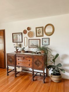 a wooden table sitting on top of a hard wood floor next to a potted plant