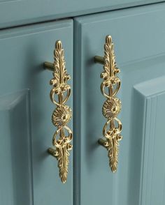 two gold door handles on a blue cabinet