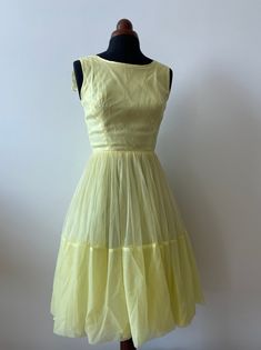 This silky yellow fit and flare dress is perfect for spring and summer. It has a lined, full skirt with multiple layers, and a zipper closure. It features a large bow detail in the back. Please note: the zipper does close all the way, it just didn't fit on my mannequin! | condition | great: This dress is in great condition, it has no spots or tears. The hook and eye closures may need to be replaced. | measurements | fits a modern day xs bust: 32 inches waist: 22 inches hips: free fabric: blend A Yellow Vintage A-line Dress For Spring, Yellow A-line Vintage Dress For Spring, Spring Yellow A-line Vintage Dress, 1950s Style Yellow Dress For Garden Party, Yellow 1950s Style Dress For Garden Party, Yellow Vintage Dress 1950s Style For Spring, Yellow Vintage Dress, 1950s Style For Spring, 1950s Style Vintage Yellow Dress For Spring, Yellow A-line Vintage Dress For Summer