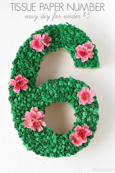 a number made out of green grass with pink flowers