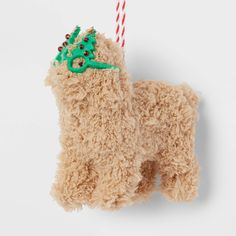 a dog ornament hanging on a wall with a candy cane in it's mouth