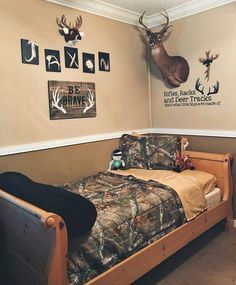 a bed room with a neatly made bed and deer head on the wall