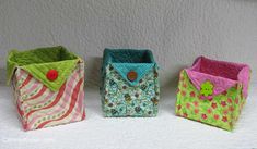 three small purses sitting on top of a white table