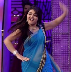 a woman in a blue sari dancing on stage