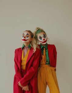 two people dressed in clown makeup standing next to each other with their hands on their hipss