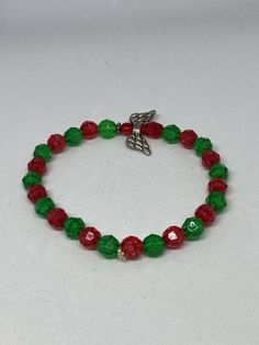 This is a Christmas Angel bracelet.  It would make a cute gift for a little girl for Christmas. It would make a perfect gift for a stocking stuffer. It has a red Angel bead in the middle. It has red and green 6mm faceted beads. It was made with .8mm sturdy stretch string. I tie it several times to prevent breakage. It fits girls ages 5-8. It stretches to fit on the wrist. All items are ready to be shipped I do combined shipping. Items ship in 2-5 business days. Check out more items at: http://ww Adjustable Beaded Bracelet Christmas Gift, Adjustable Christmas Bracelets, Adjustable Christmas Beaded Bracelets, Red Christmas Festive Bracelets, Christmas Holiday Jewelry Bracelet, Easter Bunny Girl, Angel Bracelet, Candy Bracelet, Kids Bracelets