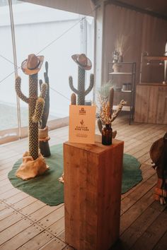 three cactus statues are on display in a room with wood flooring and green rugs