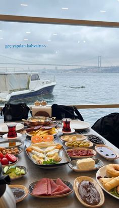 a table filled with lots of food next to the ocean