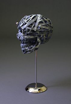 a piece of art that is on a metal stand in the shape of a human head