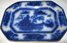 a blue and white plate with an ornate design on the bottom, sitting on a table