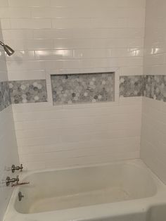 a bath tub sitting under a window in a bathroom