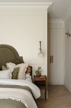 a bedroom with white walls and wooden floors