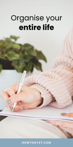 a woman writing on a notebook with the words organize your entire life