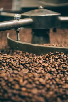 coffee beans are being roasted in a roaster with two grinders on the side