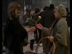 two women standing next to each other in front of a basket with a flower on it