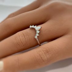 a woman's hand wearing a ring with three stones on the middle of it