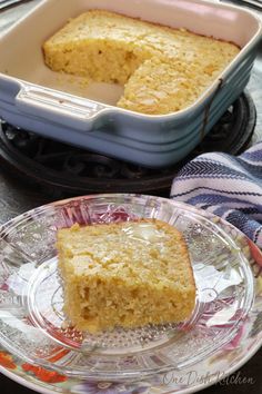 a piece of cake sitting on top of a glass plate next to a bowl and fork