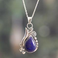 Parul and a talented team of Indian artisans present an enchanting accessory made to shine with a mystic light. This sterling silver pendant necklace is accented with leafy details that create a charming aura around a lapis lazuli cabochon, whose blue light gracefully complements the design's bewitching vibe. Bohemian Sterling Silver Pendant Drop Necklace, Nature-inspired Sterling Silver Teardrop Pendant Jewelry, Sterling Silver Necklace With Natural Stone Flower Pendant, Sterling Silver Flower Pendant Necklace With Natural Stones, Blue Nature-inspired Round Pendant Necklace, Silver Lapis Lazuli Round Pendant Necklace, Silver Necklace With Round Lapis Lazuli Pendant, Sapphire Teardrop Pendant Necklace In Sterling Silver, Silver Lapis Lazuli Necklaces With Spiritual Style