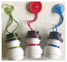 three different colored buttons are attached to some plastic bottles with string on the top one is red, white, and blue