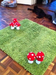 three red mushrooms sitting on top of a green rug in the middle of a living room