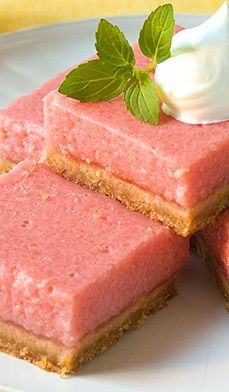 three pieces of dessert sitting on top of a white plate with whipped cream and mint