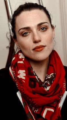 a woman wearing a red scarf and orange lipstick