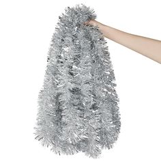 a hand holding a silver tinsel christmas tree