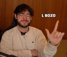 a man sitting in an office chair making the peace sign with his hand and wearing glasses