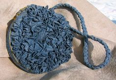 a blue purse sitting on top of a piece of cloth