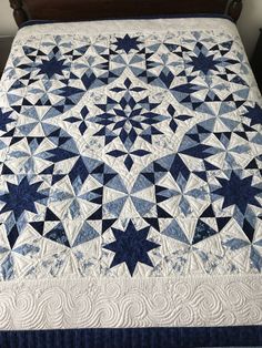 a blue and white quilt on top of a bed