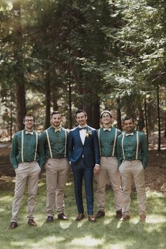 a group of men standing next to each other in front of trees