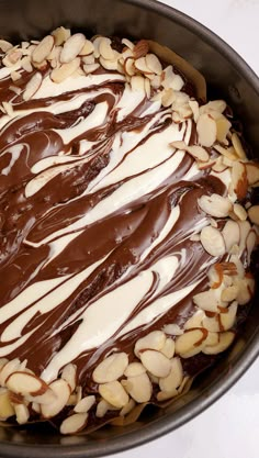 a chocolate cake with almonds on top in a pan