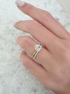 a woman's hand with a diamond ring on it