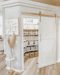 an open pantry door in the middle of a room with white walls and wood floors