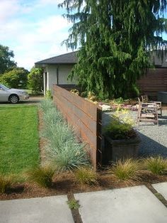 a large wooden fence in the middle of a yard next to a table and chairs